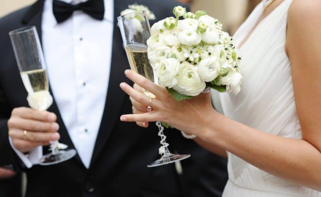 Bride and groom holding champagne glasses Bride and groom are holding champagne glasses